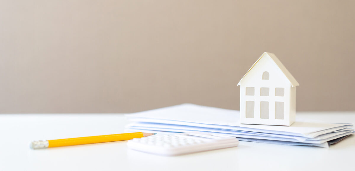 close up home’s model on group of mail letter invoice form bank with pencil and calculator on the table for family expense monthly concept